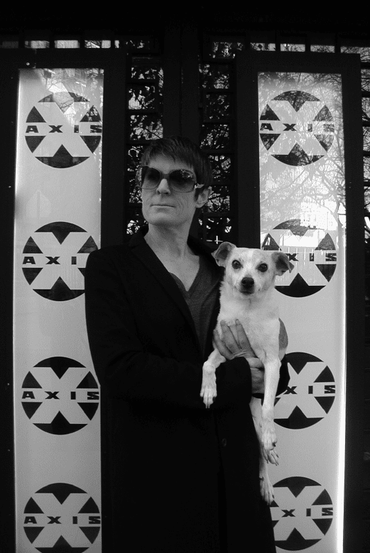 Randall Sharp holding a dog in front of Axis Theater
